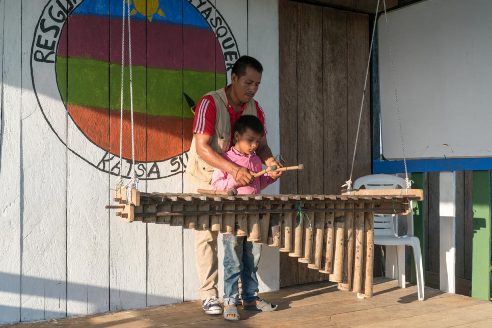 أرماندو كواسالوزان باي، 38 عاماً، يعلّم ابن أخيه كيف يعزف على الماريمبا – وهي آلة نقرية مصنوعة من الخيزران وتقليدية في ثقافة الآوا.