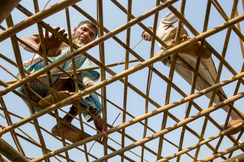 اللاجئ محمد إسحاق (يسار) يقوي سقف مأواه بقضبان من الخيزران قدمتها المفوضية لسكان مخيم كوتوبالونغ للاجئين، بنغلاديش، قبل الأمطار الموسمية.