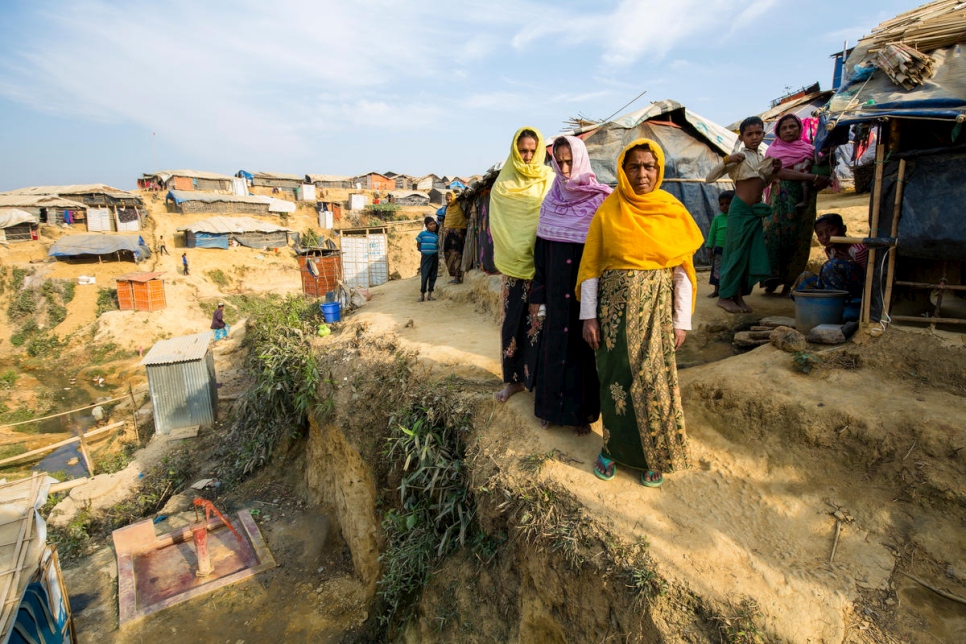 سراج بيغوم، 38 عاماً، بالوشاح الأصفر ومريم خاتون، 60 عاماً، بالوشاح البنفسجي ونور نهار، 45 عاماً، بالوشاح البرتقالي، يقفن خارج مأواهن في مخيم كوتوبالونغ للاجئين، بنغلاديش. يقع منزلهن على تلة شديدة الانحدار معرضة لخطر الانهيار خلال الأمطار الموسمية.