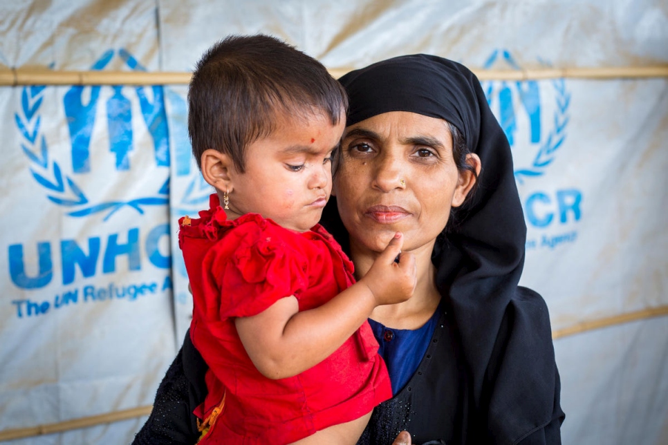 خاتيمونيسا، 40 عاماً، تحمل ابنتها في نقطة معلومات خاصة بالمفوضية في مخيم كوتوبالونغ للاجئين، بنغلاديش.