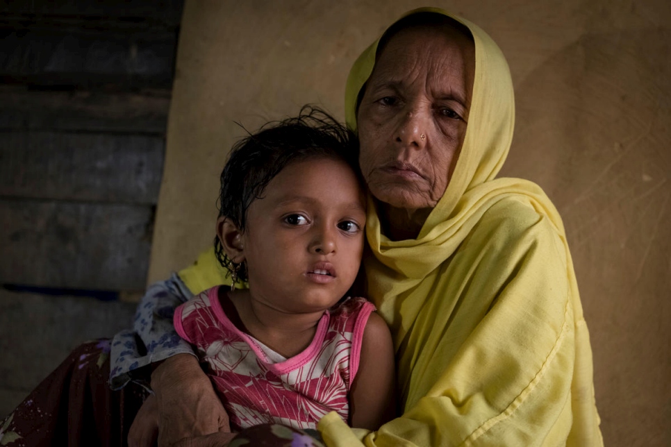 اللاجئة موتيباتو (55 عاماً) تحمل حفيدتها بالتبني في ملجأ في جنوب شرق بنغلادش بعدما فرت من ميانمار في عام 2017.