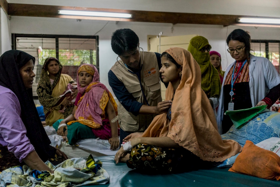 سايليش راجبانشي، طبيب نسائي وتوليد يعمل لدى صندوق الأمم المتحدة للسكان، يفحص ميلاشي، البالغة من العمر 18 عاماً، وهي لاجئة من الروهينغا، في جناح مختلط فيه مرضى بنغلاديشيين، في مستشفى سادار في كوكس بازار في بنغلاديش.
