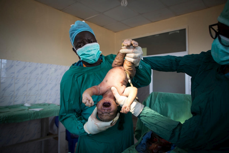 الدكتور أتار (يسار) يولّد طفلاً في مستشفى بونج. يجري المستشفى ما بين 15 و 20 عملية ولادة قيصرية في الأسبوع.
