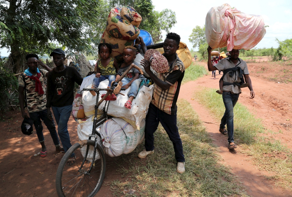 Des Congolais expulsés par l'Angola poussent un vélo loué pour transporter leurs enfants et leurs effets personnels à Tshikapa, près de la frontière avec l'Angola en République démocratique du Congo.  