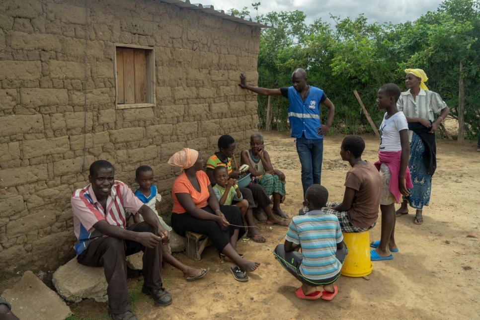 أحد زملائنا يتحدث مع عائلة اللاجئة الرواندية ماغدالينا نيراجير في مخيم تونغوغارا في زيمبابوي.