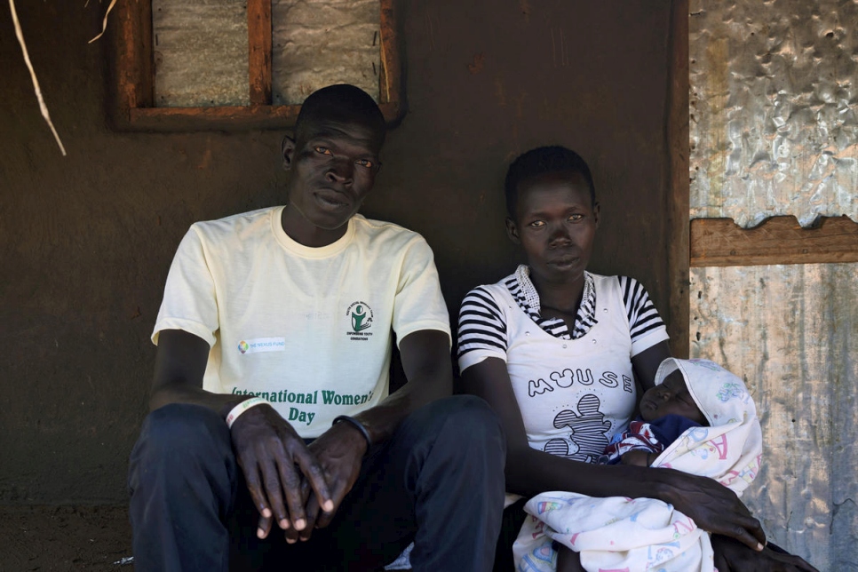 Abraham Bidal est photographié en compagnie de son épouse Betty et leur enfant âgé de deux mois. C'est la troisième fois qu'il doit se réfugier et fuir en Ouganda. À chacun de ses périples, il a remarqué qu'il y avait de mois en moins d'arbres sur la route. 