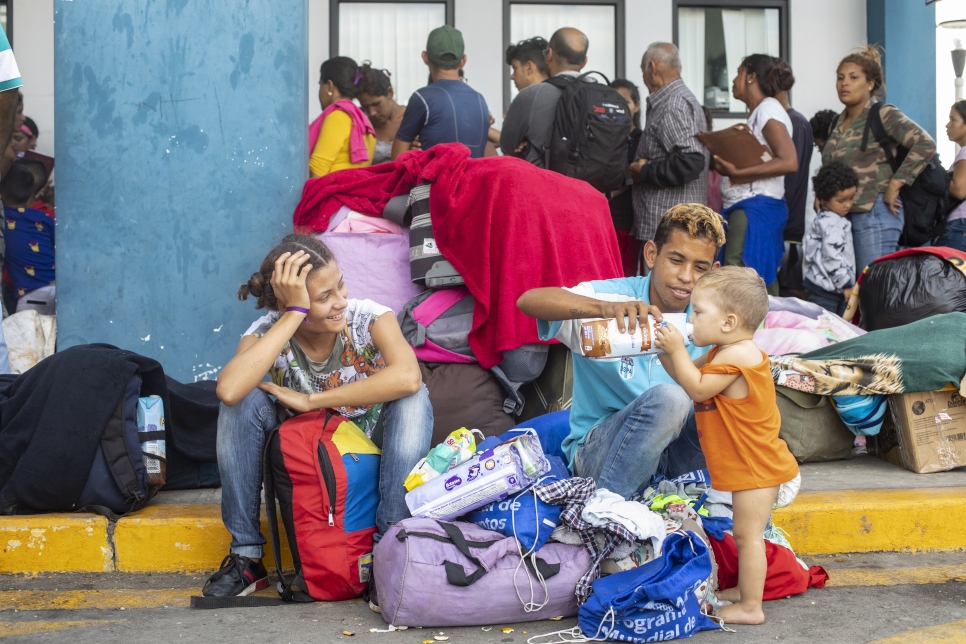 Une famille vénézuélienne attend d'entrer au Pérou depuis l'Équateur au poste frontière près de Tumbes, 14 juin 2019.  