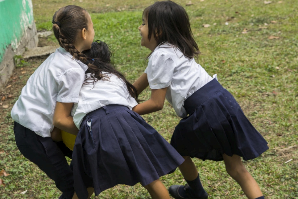 Des écolières nicaraguayennes et costariciennes jouent ensemble devant leur école. 