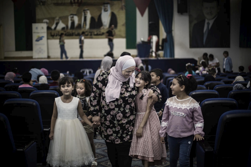 عبير خريشة محاطة بأطفال سوريين من اللاجئين خلال إحدى الأنشطة في مركز مجتمعي في مأدبا، الأردن.