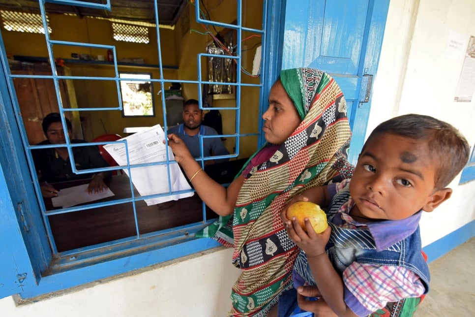 En janvier 2018, une femme, qui porte son fils dans les bras, arrive pour vérifier son nom sur le projet de liste du Registre national de citoyenneté (NRC) dans un centre NRC du village de Chandamari, dans l'État d'Assam, au nord-est de l'Inde. 