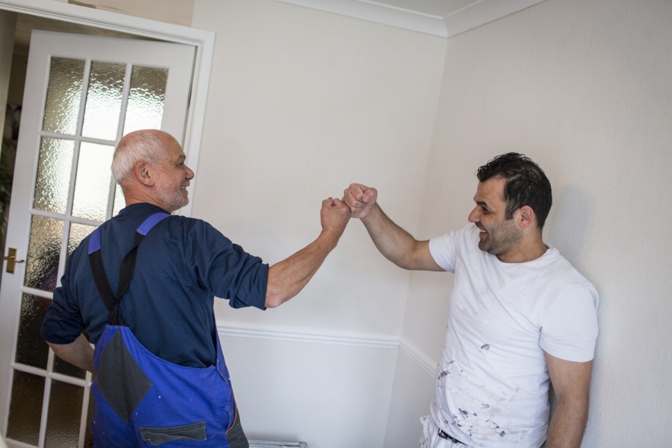 Syrian refugee Hani (right) shares a joke with decorator Trevor in Devon, UK, where he was resettled with his family in 2017.