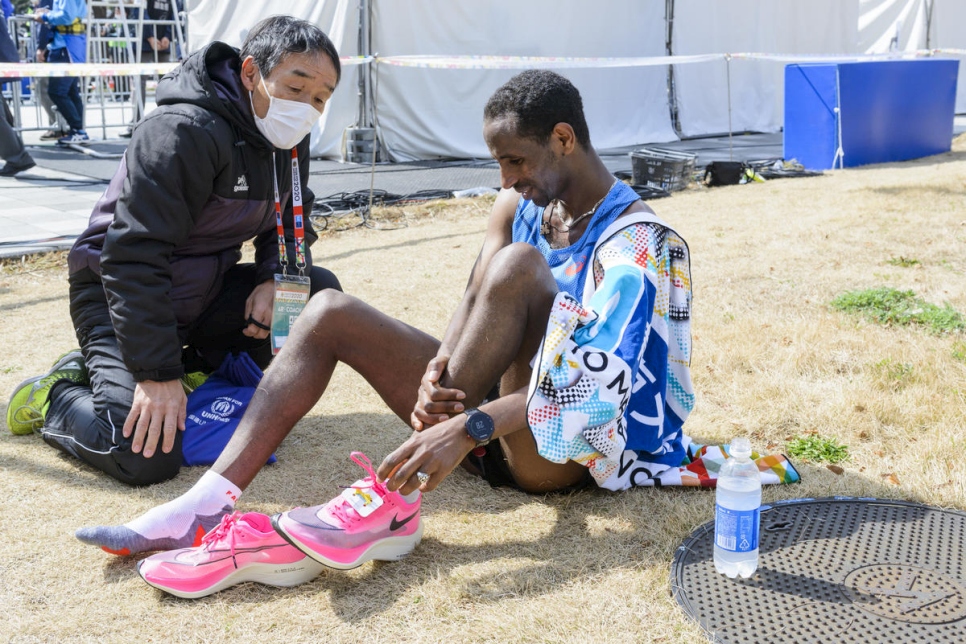 يوناس يخلع حذائه لتخفيف الألم عن قدميه المتورمتين بعد أكثر من ساعتين من السباق.