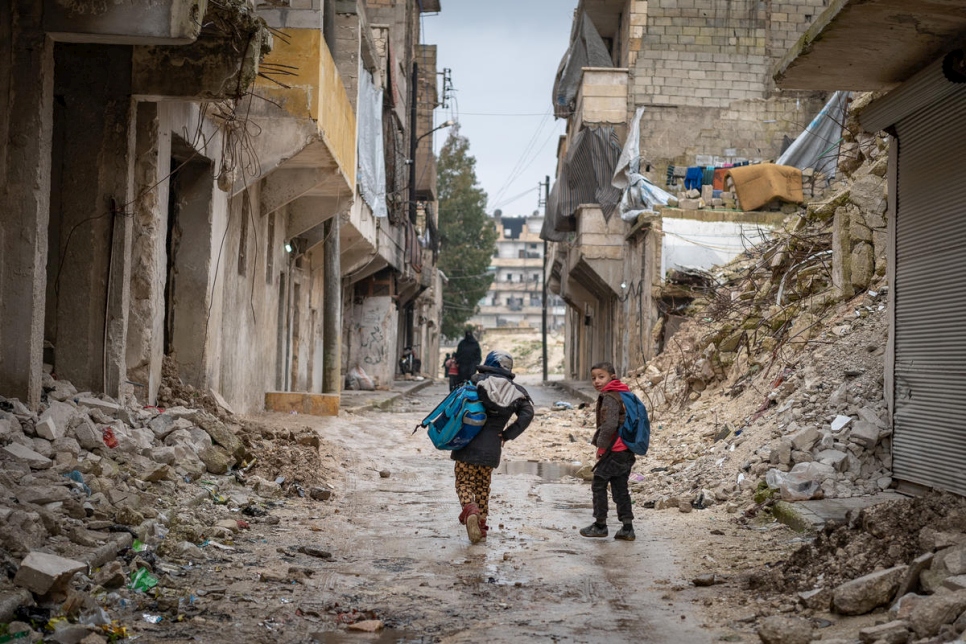 مدنيون نزحوا بسبب الصراع السوري يمشون عبر أنقاض منازلهم بعد عودتهم إلى مدينة حلب.
