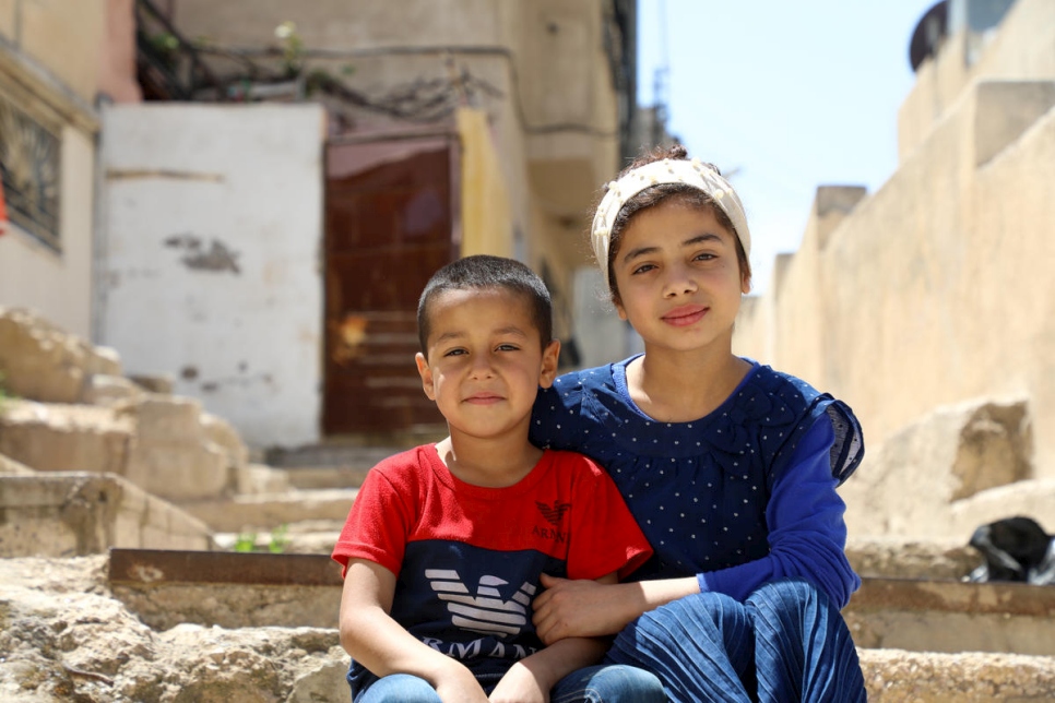 نادية، 12 سنة، وشقيقها الأصغر عابد، 5 أعوام، يجلسان خارج منزلهما في شرق العاصمة الأردنية عمًان. يتناوبان مع أشقائهما الثلاثة الآخرين استخدام تلفزيون العائلة والهاتف المحمول.