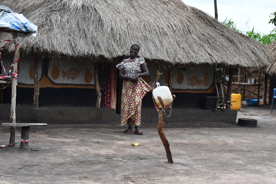 Ferida, une réfugiée sud-soudanaise, chez elle à Bele, en République démocratique du Congo, avec son point d'eau pour le lavage des mains au premier plan. 
