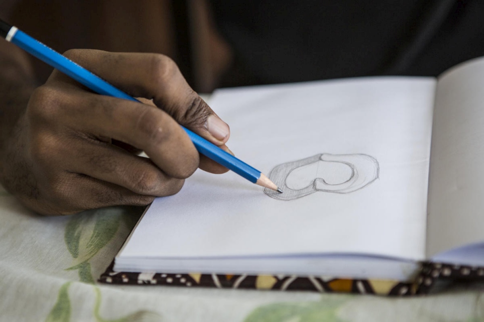 يرسم أوبليرو الرموز التعبيرية ليوم اللاجئ العالمي 2020 على الورق قبل نقلها على الكمبيوتر. 