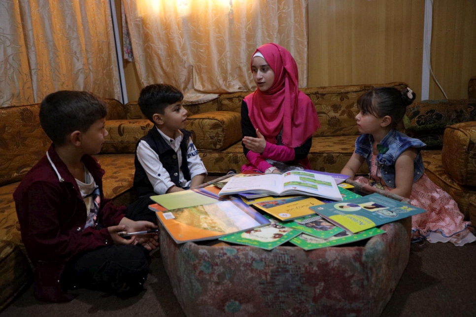 خلال فترة إغلاق المدارس في مخيم الزعتري للاجئين في الأردن، تساعد اللاجئة السورية سدرة مدين الغوثاني البالغة من العمر 14 عاماً شقيقها الأصغر وأطفال جيرانها على الدراسة في المنزل. 