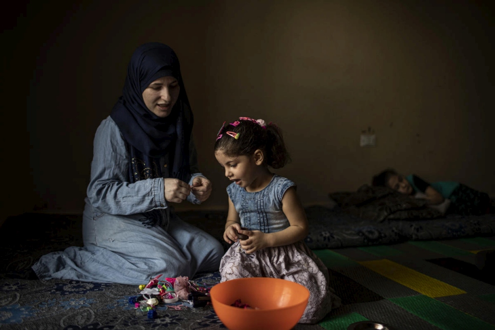 اللاجئة السورية وفاء تمشط شعر ابنتها ياسمين في منزل العائلة في برجا، لبنان.