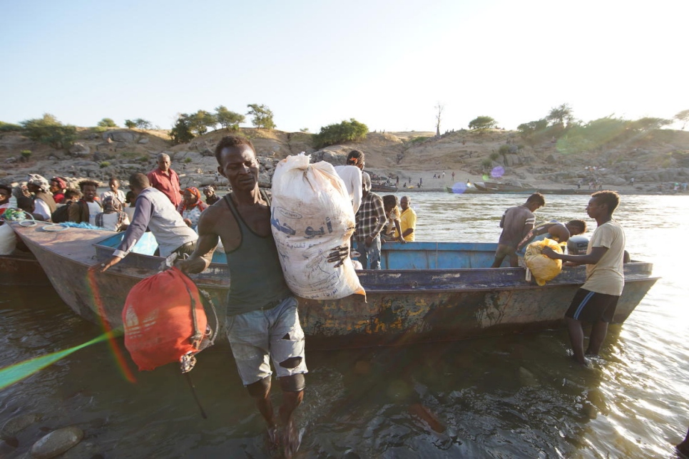 لاجئون إثيوبيون يفرون من الاشتباكات في منطقة تيغراي الشمالية في البلاد يعبرون نهر تيكيزي للوصول إلى حمداييت في السودان.