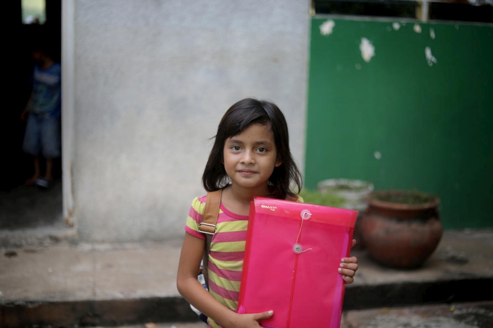 Une fillette originaire du Honduras tient le dossier des demandes d'asile de sa famille dans un centre d'hébergement financé par le HCR à Tapachula, au sud du Mexique. Novembre 2018. 