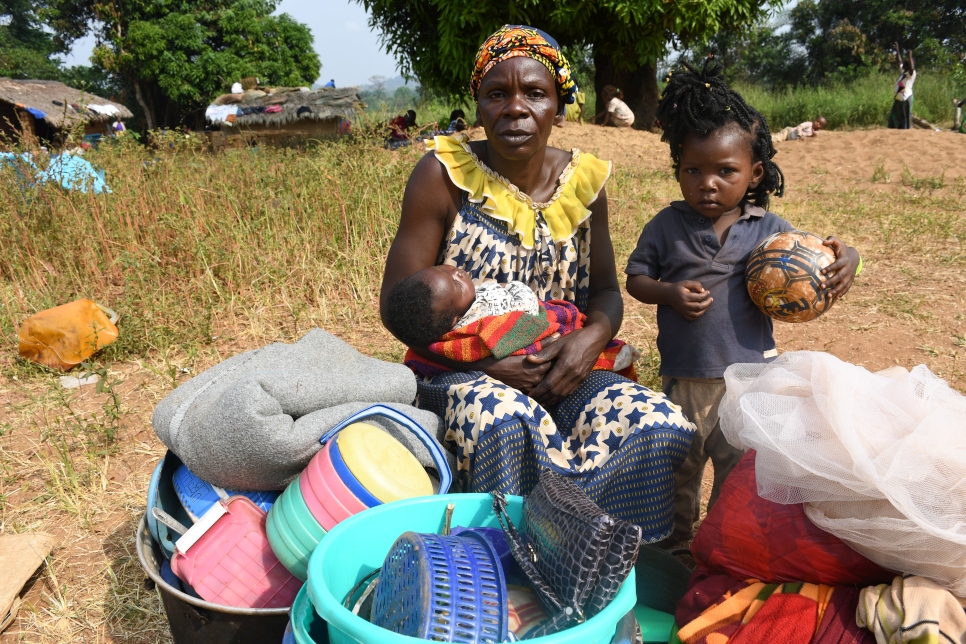 Yvette, 57 ans et réfugiée centrafricaine, est assise avec deux de ses petits-enfants dans le village de Ndu en République démocratique du Congo (RDC) après avoir fui Bangassou en République centrafricaine. 