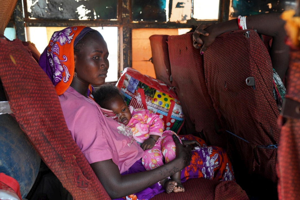 أم وطفلتها يستقلان حافلة من الخرطوم في السودان إلى بينتيو في جنوب السودان.