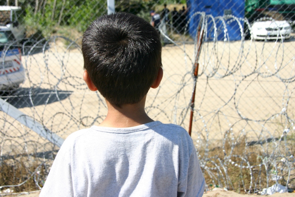 Sur cette photo d'archives datant de 2016, un enfant afghan regarde de l'autre côté d'une clôture en fil de fer barbelé au camp de réfugiés de Röszke, à la frontière hongroise avec la Serbie.  