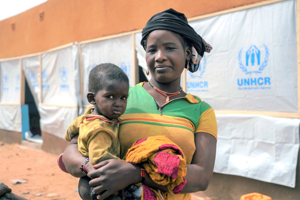Aïssata, de retour au camp de Goudoubo depuis Djibo, tient son bébé dans les bras. Elle compte parmi d'autres réfugiés maliens qui sont revenus après la réouverture de ce camp. 