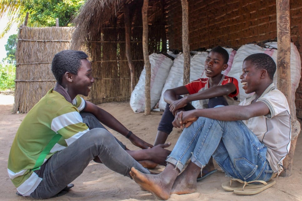 Les trois amis partagent un moment de détente au site de déplacés de Ndele à Montepuez, au Mozambique. 