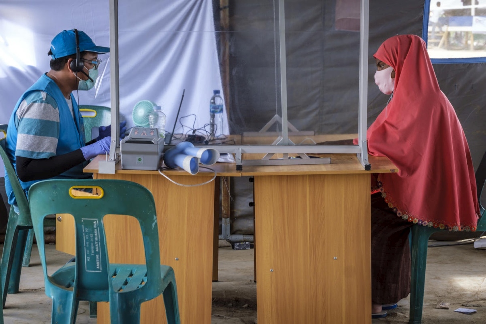 Une réfugiée rohingya du Myanmar est enregistrée par un employé du HCR dans un site de réfugiés au nord de la province d'Aceh, en Indonésie. 