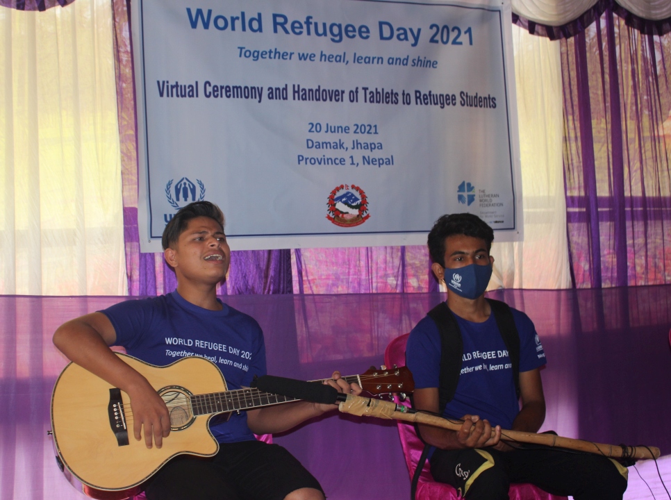 Kul Bahadur, un réfugié bhoutanais de 17 ans, joue de la guitare et interprète une chanson exprimant son amour pour son pays d'origine lors d'une cérémonie virtuelle festive pour marquer la Journée mondiale du réfugié le 20 juin 2021 à Damak, dans la Province 1 au Népal.  
