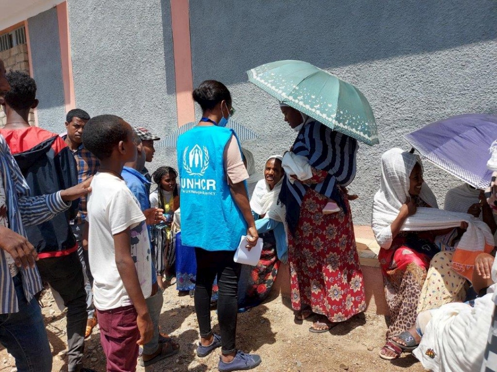 A UNHCR staff member speaks to internally displaced people in the street in Axum, in the Tigray region of Ethiopia. 
