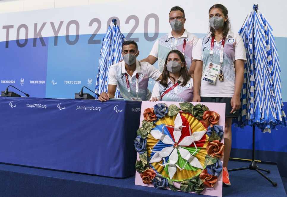أعضاء الفريق البارالمبي للاجئين يقفون مع أكثر من 3,000 طائرة ورقية خلال مؤتمر صحفي قبل دورة الألعاب البارالمبية في طوكيو 2020.