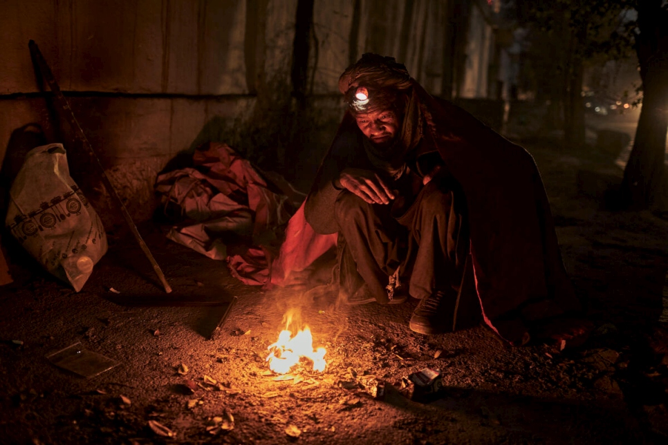 A homeless man seeks warmth from a small fire on the streets of Kabul, Afghanistan, as winter draws in.