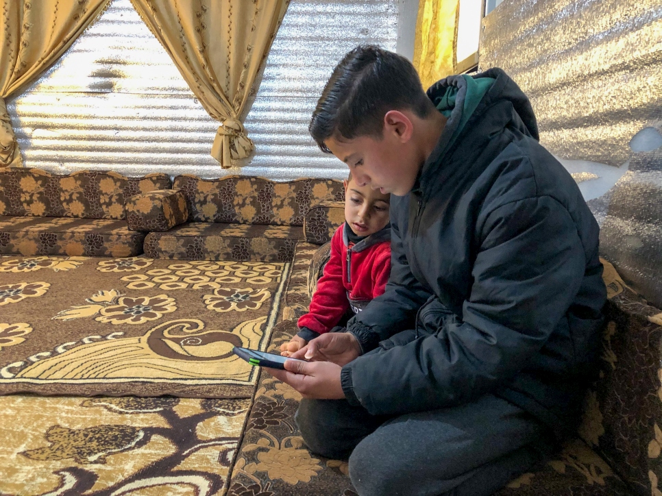 Jordan. Refugee students study from home in Azraq Refugee Camp. Mousa AlMousa, 14, and his younger brother study on his phone via the UNHCR supported Kolibri platform. 