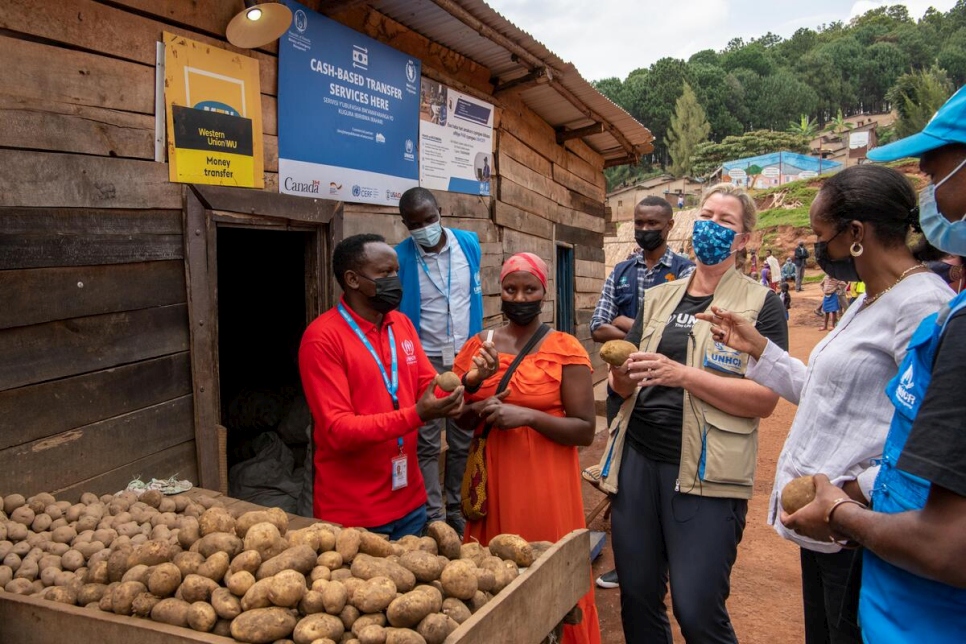 نائبة المفوض السامي، كيلي كليمنتس (في الوسط) تتحدث مع التاجر واللاجئ الكونغولي أوليف كانيانج في مخيم موغومبوا للاجئين في رواندا.