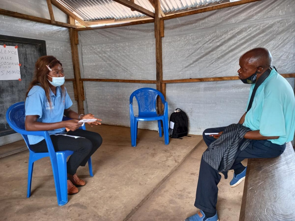 Alphonsine Mayamba discute avec un réfugié récemment vacciné dans le camp de Lóvua, en Angola. 