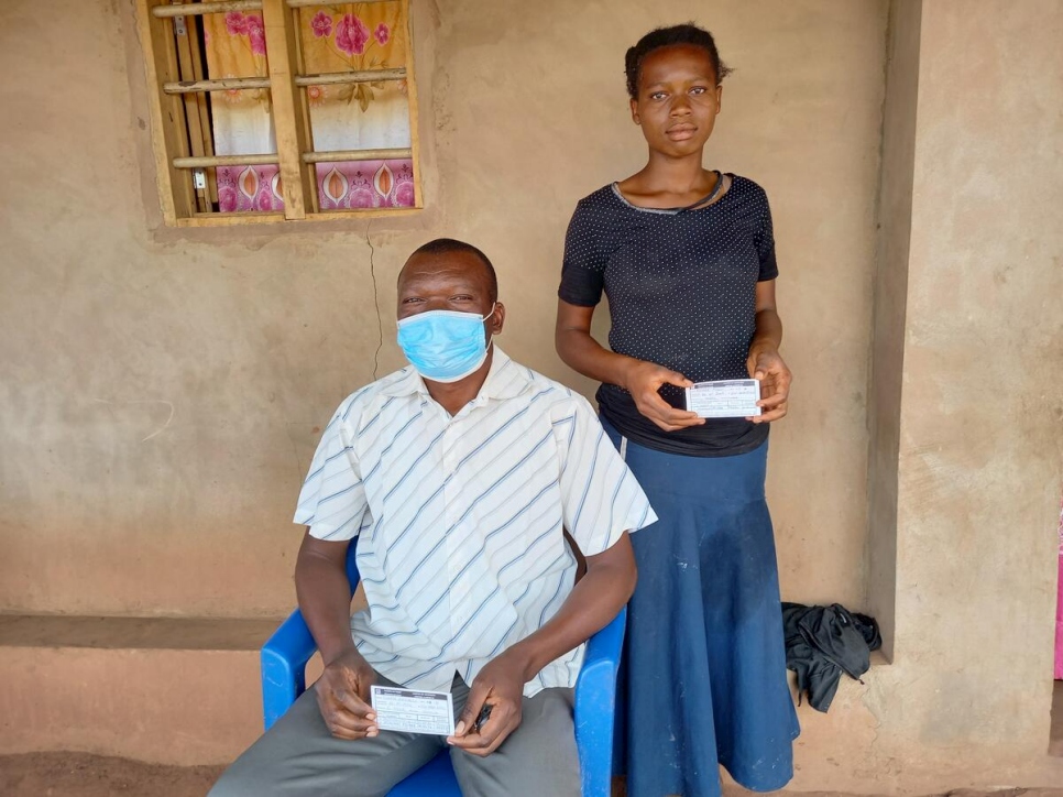 Muanza, 53 ans et sa fille Hélène montrent leurs certificats de vaccination contre le Covid-19 dans le camp de réfugiés de Lóvua, en Angola
