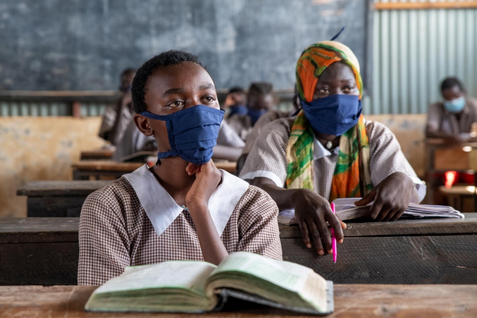 Igirubuntu Divine is a refugee from Burundi and a candidate for this year's national examination. She prefers to sit in the front row of her classroom donning her new pair of school uniform and reusable facemask she received.
