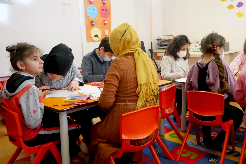 أطفال سوريون برفقة أخصائية نفسية خلال جلسة رسم في العاصمة التركية أنقرة.
