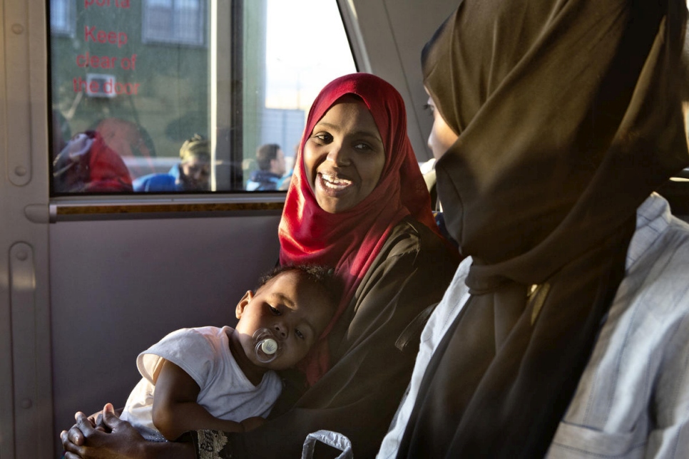 Two Somali women and a baby sit on a shuttle bus after arriving at Pratica di Mare air base in Pomezia, near Rome on an evacuation flight from Libya.