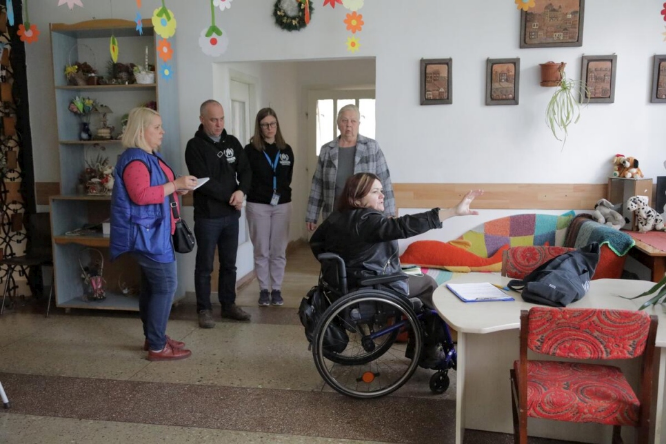 Tetiana accompagne des employés du HCR lors d'une visite du centre de réadaptation pour personnes handicapées de Velykyi Bereznyi et leur suggère comment améliorer l'accessibilité du bâtiment.  