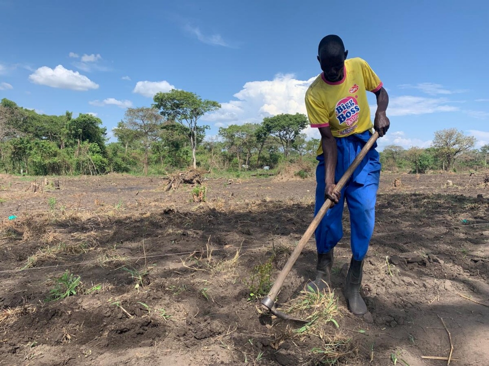 أودونغ أنتوني يحفر التربة على الأرض التي يزرعها مجتمع "كان-كويا" الزراعي.