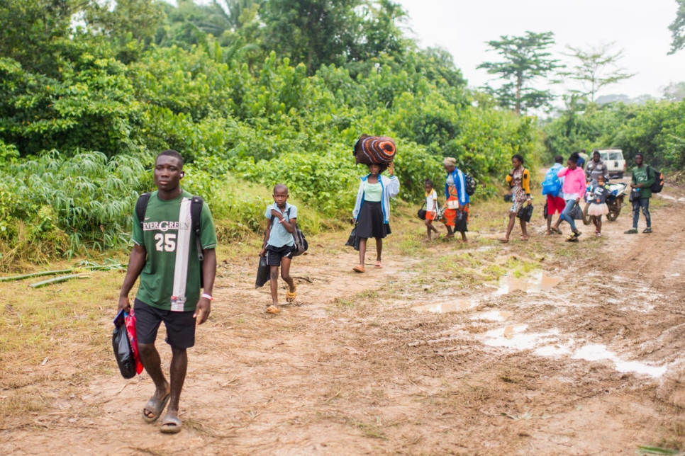 العائلات الإيفوارية وهي تقطع مسافة قصيرة سيراً على الأقدام من مخيم بوتو المؤقت (ليبيريا) إلى ضفة نهر سيستوس قبل التوجه إلى ديارها.