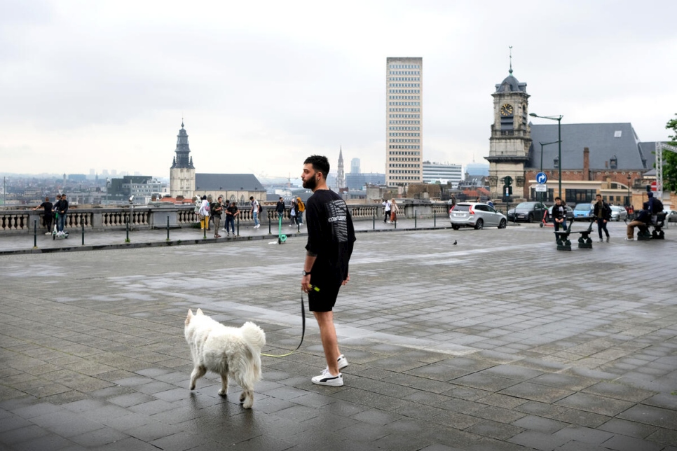 Belgium. Syrian refugee and musician Bassel out and about with his white shepherd dog Stella