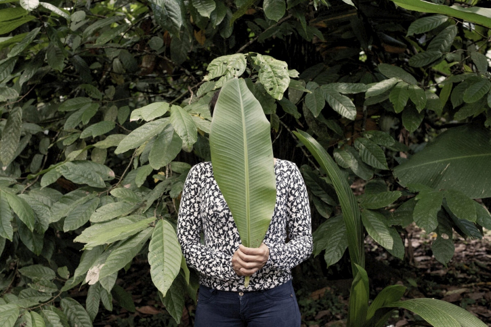 فرت ماريا*، وهي طالبة لجوء تبلغ من العمر 28 عاماً من نيكاراغوا، بعد أن تلقت عائلتها تهديدات، وتقف هنا لالتقاط صورة لها باستخدام أوراق الموز لإخفاء هويتها.