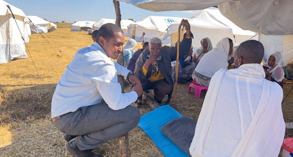 UNHCR Representative in Ethiopia, Mamadou Dian Balde (left), speaks to Eritrean refugees in the Alemwach settlement, in Ethiopia's Amhara Region.