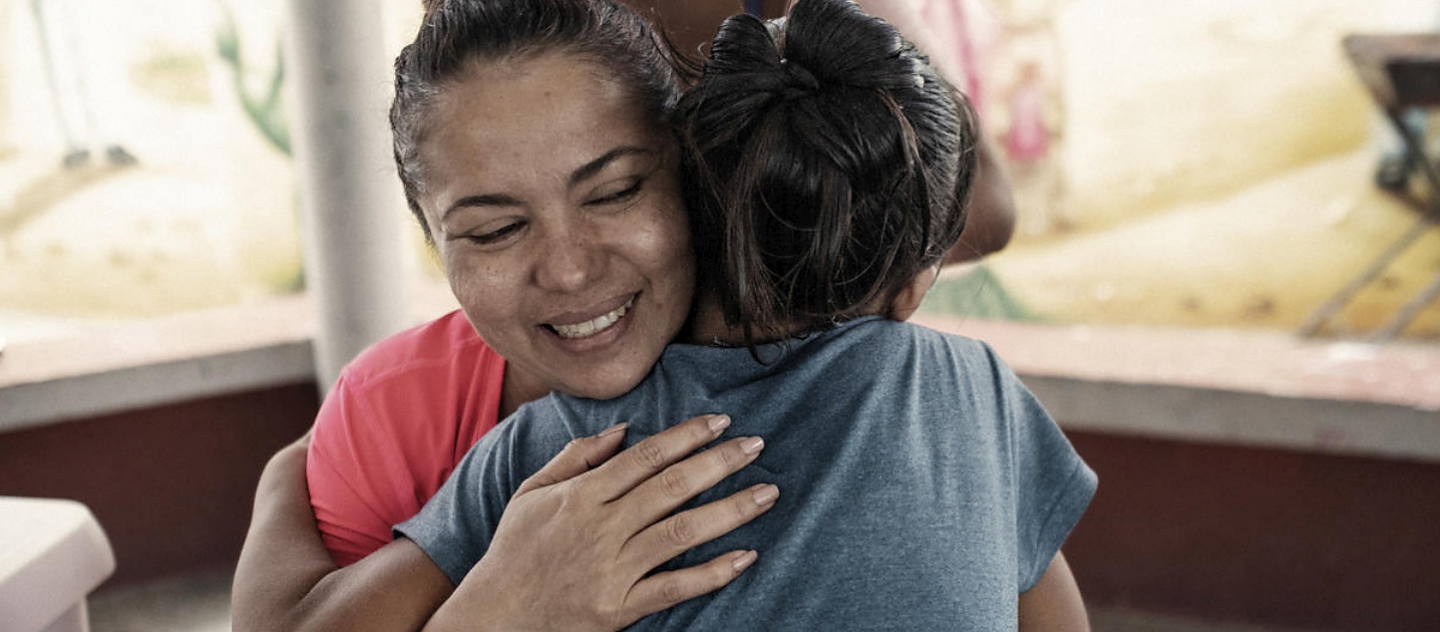 UNHCR's Nansen Refugee Award Laureate 2020 hugs a young survivor of sexual exploitation.