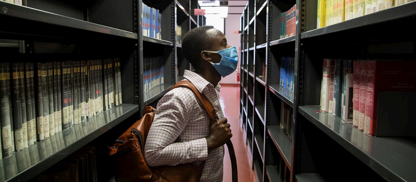 Jules, un étudiant de 26 ans originaire de la République démocratique du Congo, parcourt les étagères de la bibliothèque de sciences sociales de l'Université de Florence.   
