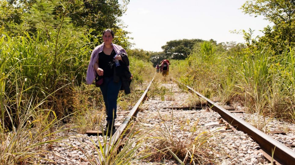 A woman fleeing El Salvador walks along the train tracks in Chiapas, Mexico.